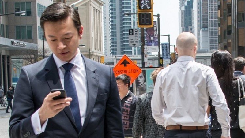 banker-looking-at-phone-street-featured-wide-750x423